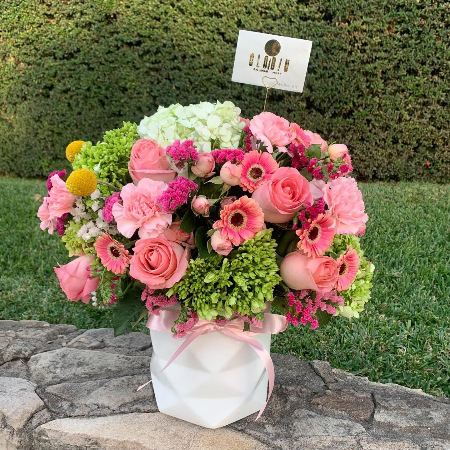 Arreglo floral de rosas, gerberas y hortensias en tonos rosa y verde