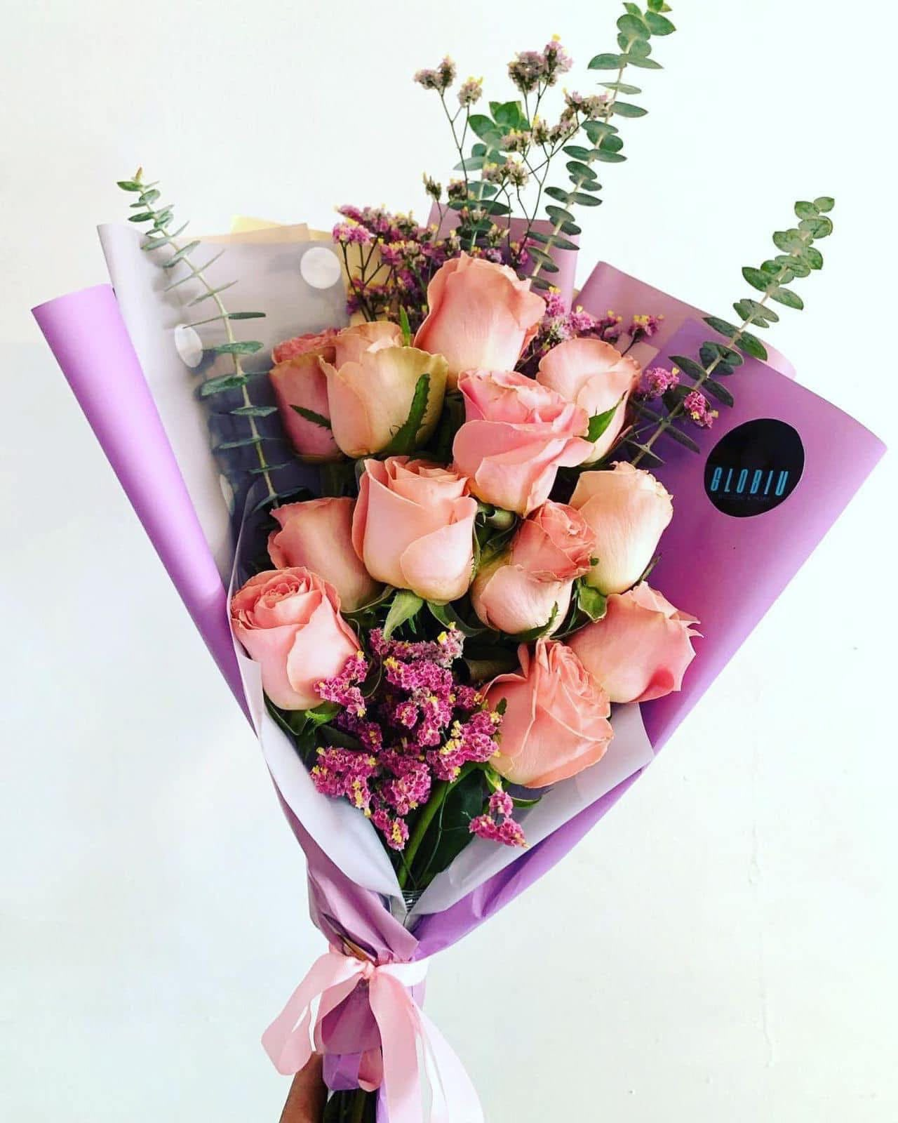 Ramo de rosas color durazno con eucalipto y envoltura violeta
